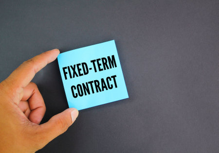 hand holding a blue paper with the word Fixed-Term Contractの写真素材