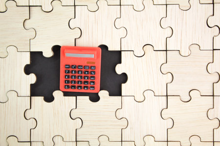 wooden puzzle with a calculator on the puzzle hole. business concept of Solution. solution conceptの写真素材