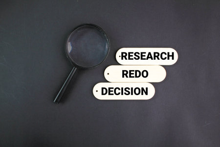 magnifying glass with the three words research, redo and decision which express the decision to redo the review. review research concept.&nbsp;の写真素材