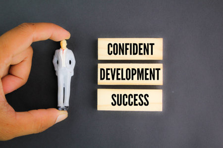 miniature people with three words of self-motivation to be successful: confident, development and success. the concept of self-confidenceの写真素材