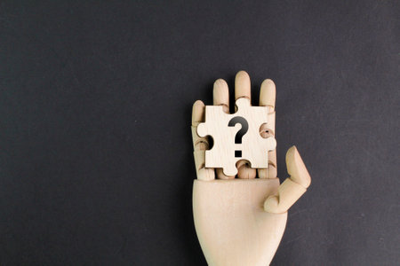 wooden hand holding puzzle with question mark icon. the concept of question or the concept of Q and...