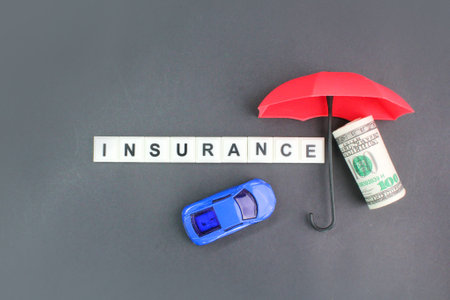 car, umbrella and money with the word insurance. vehicle insurance conceptの写真素材