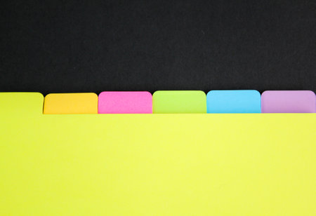 Open blank notebook with colorful sticky bookmarks on yellow paper, educational background concept border design with copy spaceの写真素材