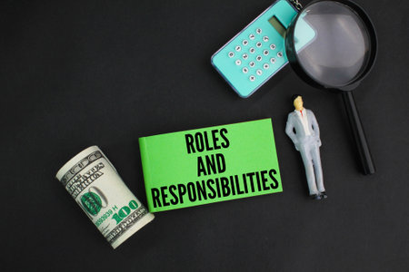 calculator, magnifying glass and paper money with the words Roles and Responsibilities.の写真素材