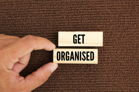 finger holding a wooden board with the word Get organized