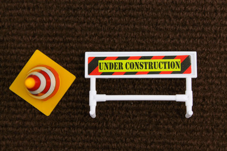 cones and signs with words under construction. concepts in maintenance. Under maintenance