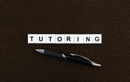 pen and alphabet letters with the word tutoring. the concept of learning or educationの写真素材