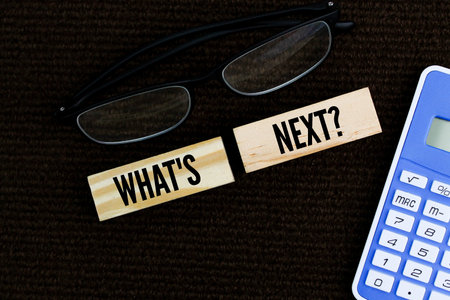 glasses and a calculator with the question word What's Next?の写真素材