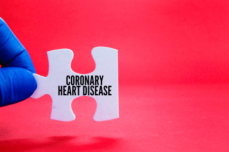 finger holding a white puzzle with the word coronary heart disease. disease or hospital conceptの写真素材