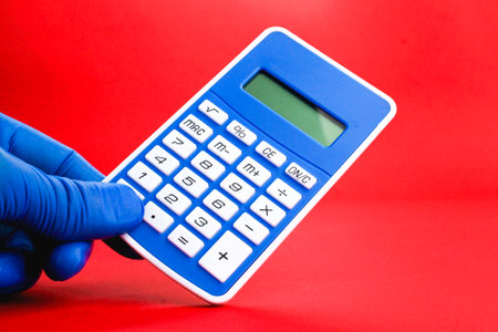 hand holding a blue calculator. the concept of an accountant or calculation. mathematical conceptsの写真素材