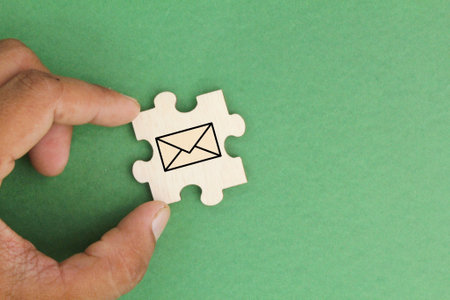 wooden puzzle with an unopened Email icon. email support concept. the concept of email and the concept of communication through emailの写真素材