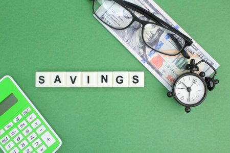 paper money, glasses and an alarm clock with the word savings. the concept of future savings