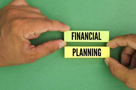 hand holding colored paper with the word FINANCIAL PLANNING. financial planning concept.