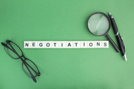 judge's hammer, little people, magnifying glass with the word negotiations. the concept of negotiation or discussion or deal conceptの写真素材