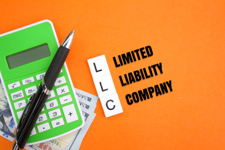 calculator, pen and paper money with the letters LLC or the word Limited Liability Company. business company conceptの写真素材