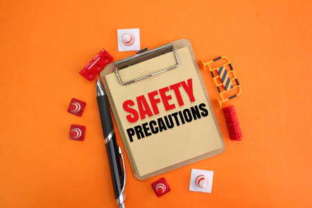 pens, notebooks and cones with the words safety precautions. the concept of safety or cautionの写真素材