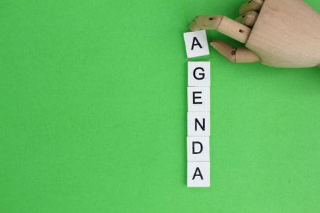 Wooden hands and alphabets with the word agenda. The concept of today's agenda. The concept of...