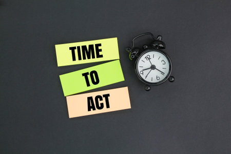 bell hours and colored paper with the word time to act. the concept of time to actの写真素材