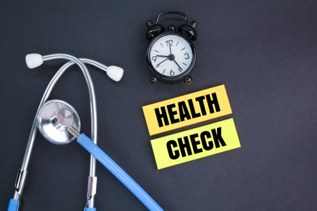 stethoscope, alarm clock and colored paper with the word health check. the concept of health...