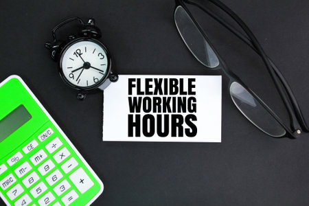 calculator, alarm clock and glasses with the words flexible working hours. the concept of working flexiblyの写真素材