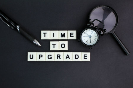 bell clock and alphabet letters with the word time to upgrade. system upgrade concept or somethingの写真素材
