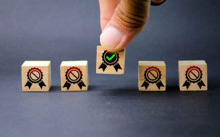 wooden cube with quality and non-quality icons. the concept of seeking quality. hand picked quality. Guarantee, Standards, ISO certification and standardization concept.の写真素材