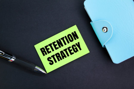 colored pen, book and paper with the word retention strategy. strategy concept for retentionの写真素材