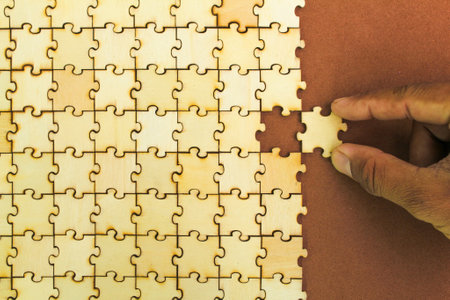 hand holding the last puzzle to be solved or finished. Compliting final task. logical thinking, business logic, Conundrum, decision, solutions, rational, mission, success, goals anの写真素材