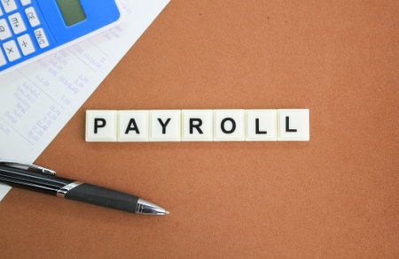 receipt, calculator, pen and letters of the alphabet with the word payroll. salary concept. salary payment conceptの写真素材