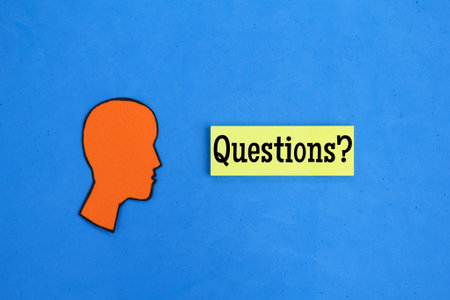 shape of a person's head and colored paper with the word question question. the concept of faq or question and answerの写真素材