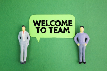 Two miniature people and a conversation bubble with the words "welcome to the team". join the group conceptの写真素材
