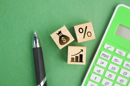 calculator, pen and wooden cube with percent, money, profit icons. business management concept. investment concept.の写真素材