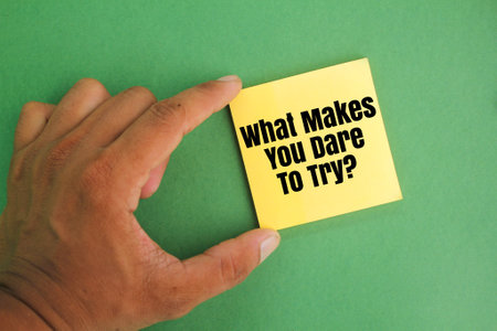 hand holding colored paper with the question word what makes you dare to try. the concept of courage. the concept of tryingの写真素材