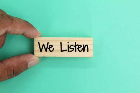 hand holding a stick with the word we listen. the concept of listening or respondingの写真素材