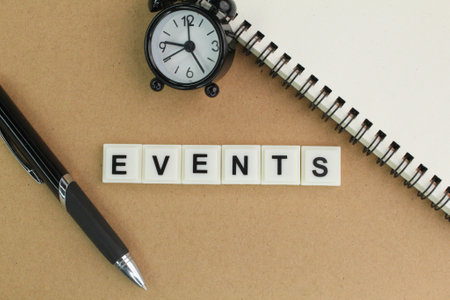 pen, alarm clock and book with the word events alphabet. the concept of something happening or an eventの写真素材