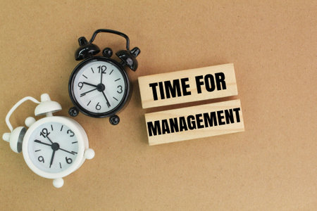 bell and stick clock with time word for management. time management concept