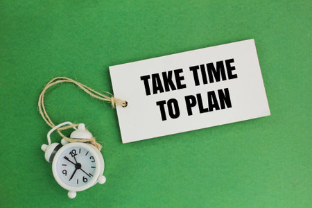 an alarm clock and a paper tag with the word TAKE TIME TO PLAN. Planning increases productivity and...