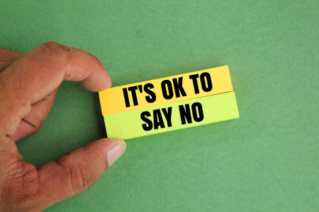hand holding colored paper with the words IT'S OK TO SAY NOの写真素材