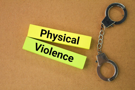 iron handcuffs and colored paper with the word physical violence