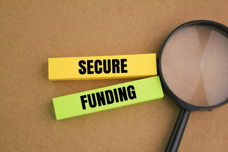 magnifying glass and colored paper with the word Secure fundingの写真素材