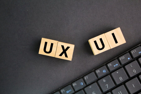 laptop keyboard and wooden blocks with the letters UX and UI. User Interface and User Experience design concept.の写真素材