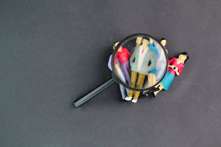 magnifying glass and a group of miniature people. Human resource management and recruitment...