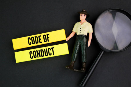 magnifying glass, miniature people and colored paper with the word code of conduct. the concept of behaviorの写真素材