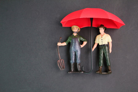 two workers under an umbrella. the concept of worker protection. human rights protection and safe community of people. Safety at workplace, safety first, hazards, protections, healの写真素材