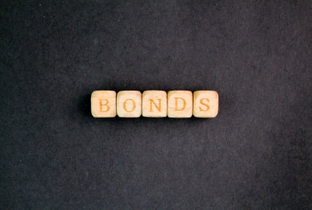 banknotes and letters of the alphabet with the word bonds. a relationship between people or groups based on shared feelings, interests, or experiences.の写真素材
