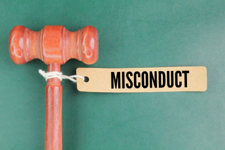 the judge's gavel and a paper tag with the word misconduct. employee or student fault concept