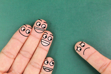 fingers with three angry facial expressions and one sad facial expression. the concept of racial...