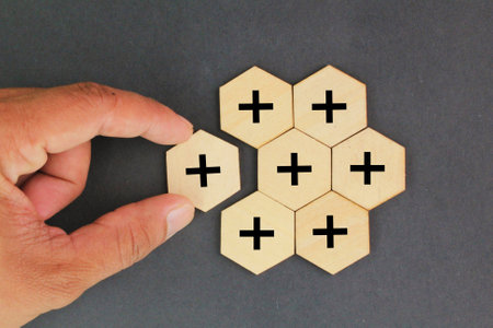 Hexagon and plus signs are stacked up. Added value or increasing benefits concept. Progress and...