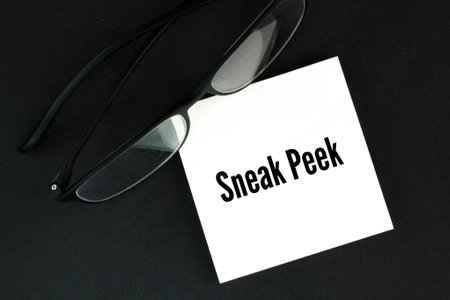 glasses and white paper with the word SNEAK PEEK. an opportunity to see something before it is officially availableの写真素材