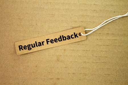 tag the paper with the words Regular Feedback. consistent input regarding performance, progress, or behavior, often in a professional or educational context.の写真素材